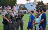 L.A. County Sheriff officers and kids talking in park
